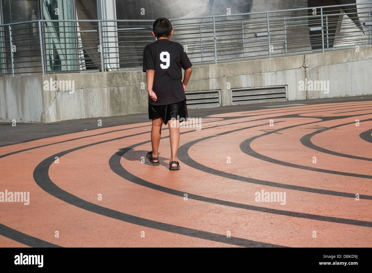 Ein Junge ging Kreise in einem gemalten Labyrinth auf dem Boden Stockfoto