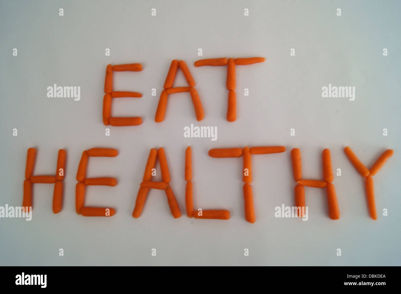 Ernähren Sie sich gesund geschrieben mit Karotten auf weißem Hintergrund Stockfoto
