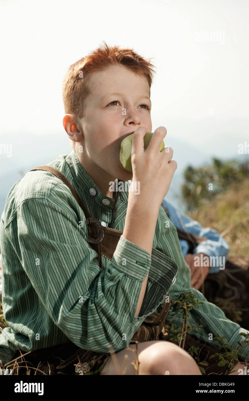 Deutschland, Bayern, junge in traditioneller Kleidung Essen eines Apfels Stockfoto