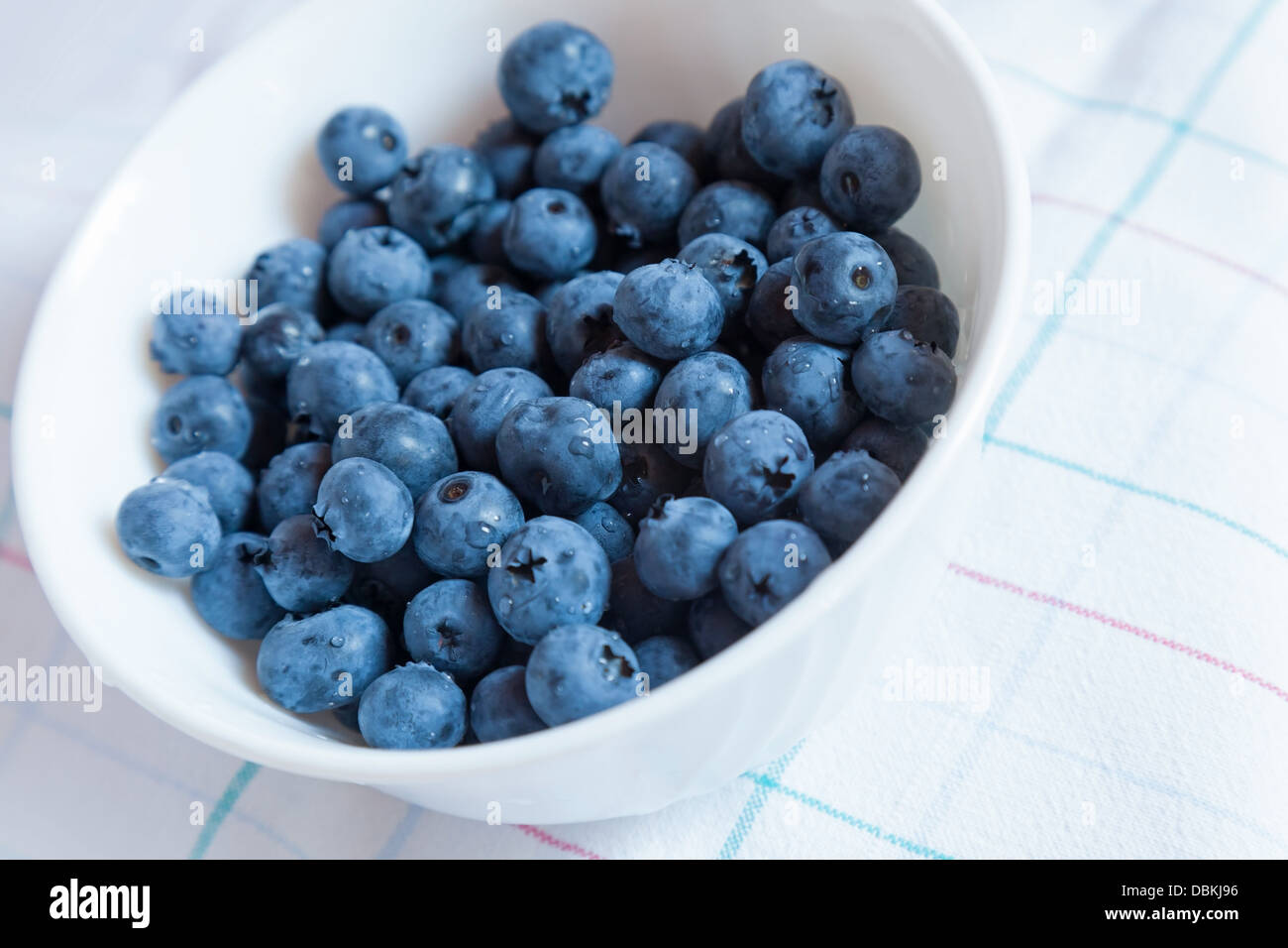 Heidelbeeren in der Schüssel auf weiße Tischdecke Stockfoto