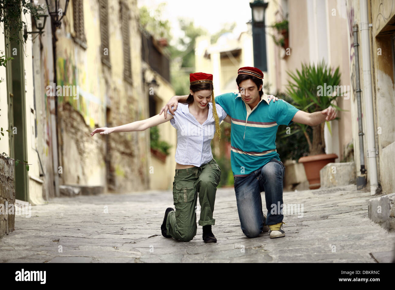 Paar mit griechischen Kostüm Hüte tanzen Stockfoto
