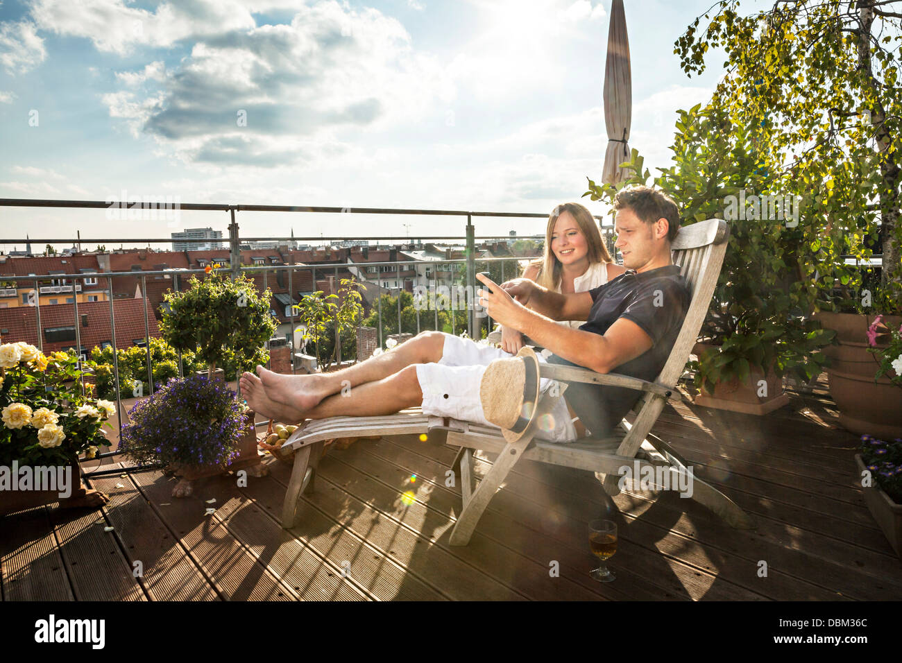 Paar auf Balkon mit Handy, München, Bayern, Deutschland, Europa Stockfoto