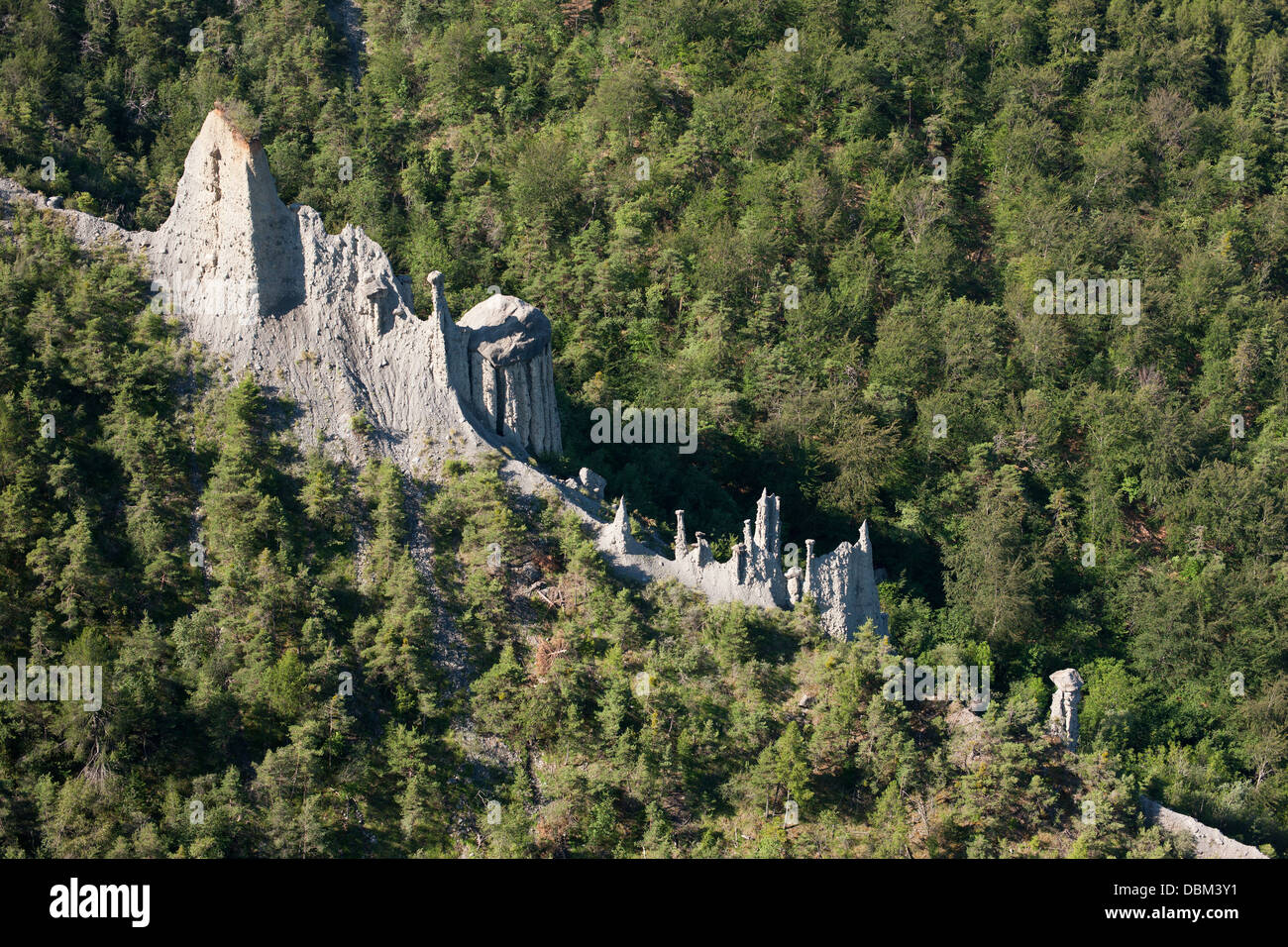 LUFTAUFNAHME. Geologische Bildung von Hoodoos an den bewaldeten Hängen oberhalb des Serre-Ponçon-Sees. Le Sauze-du-Lac, Hautes-Alpes, Frankreich. Stockfoto