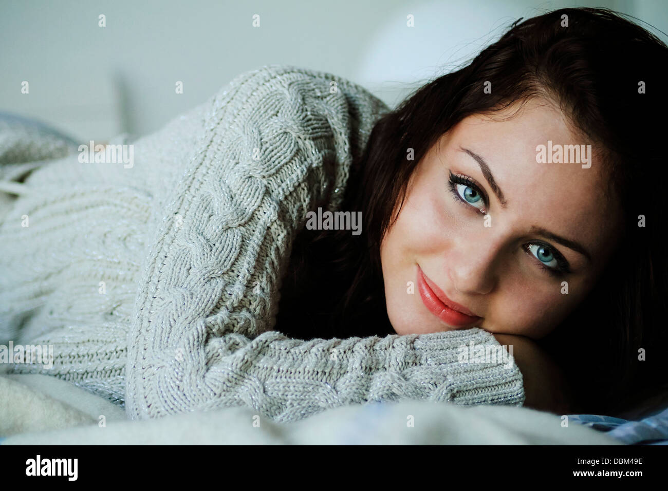 Frau mit braunen Haaren liegend auf dem Bett, Kopenhagen, Dänemark Stockfoto