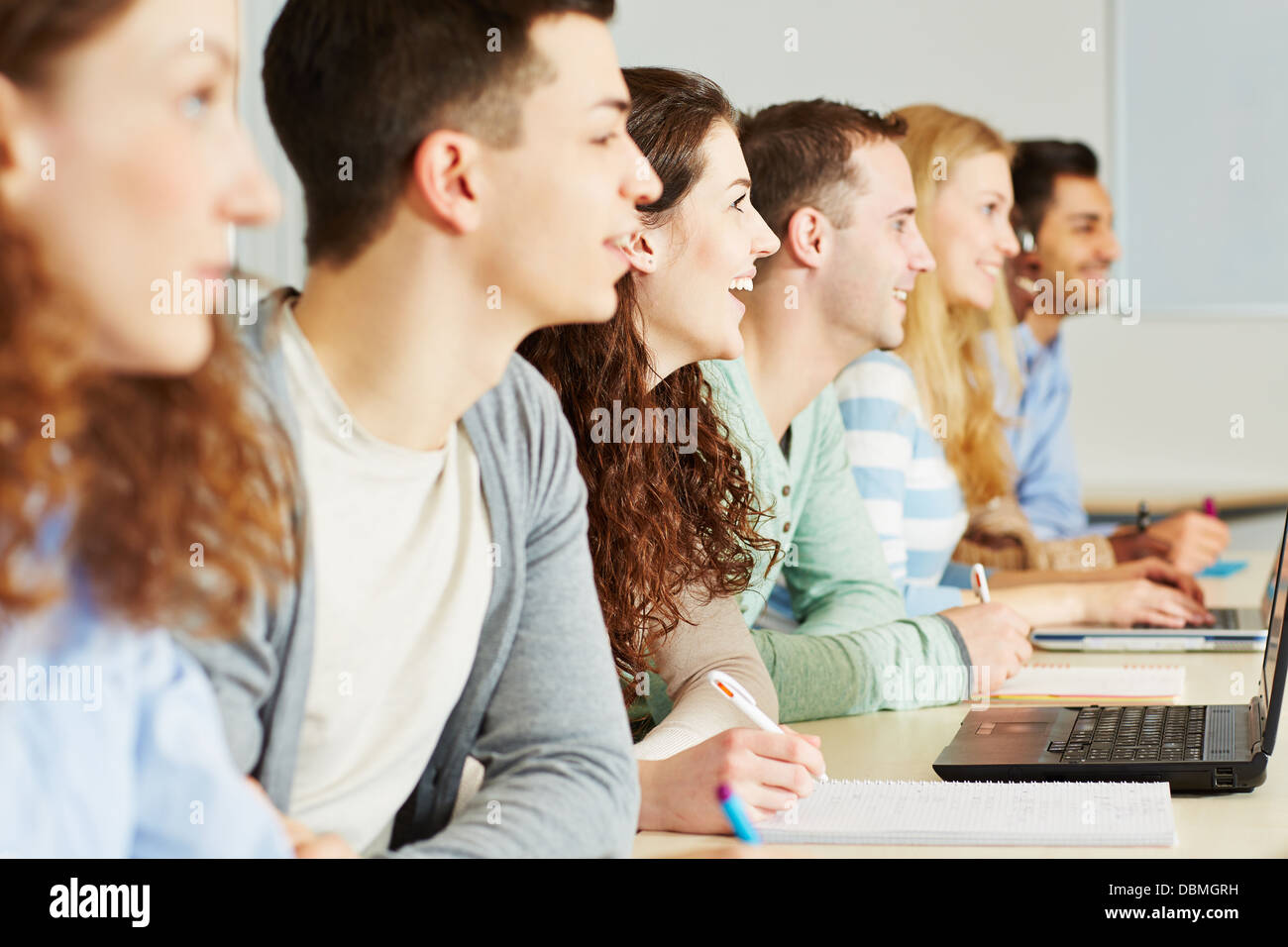 Viele glückliche Schüler im Klassenzimmer einer Schule gemeinsam lernen Stockfoto