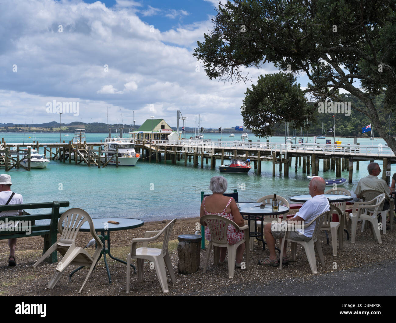dh Russell Bucht der Inseln Neuseeland älteres Ehepaar entspannende Cafe Tisch Mole Boote Stockfoto