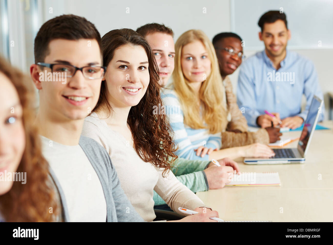 Klasse der vielen lächelnden Studenten an einer Universität Stockfoto