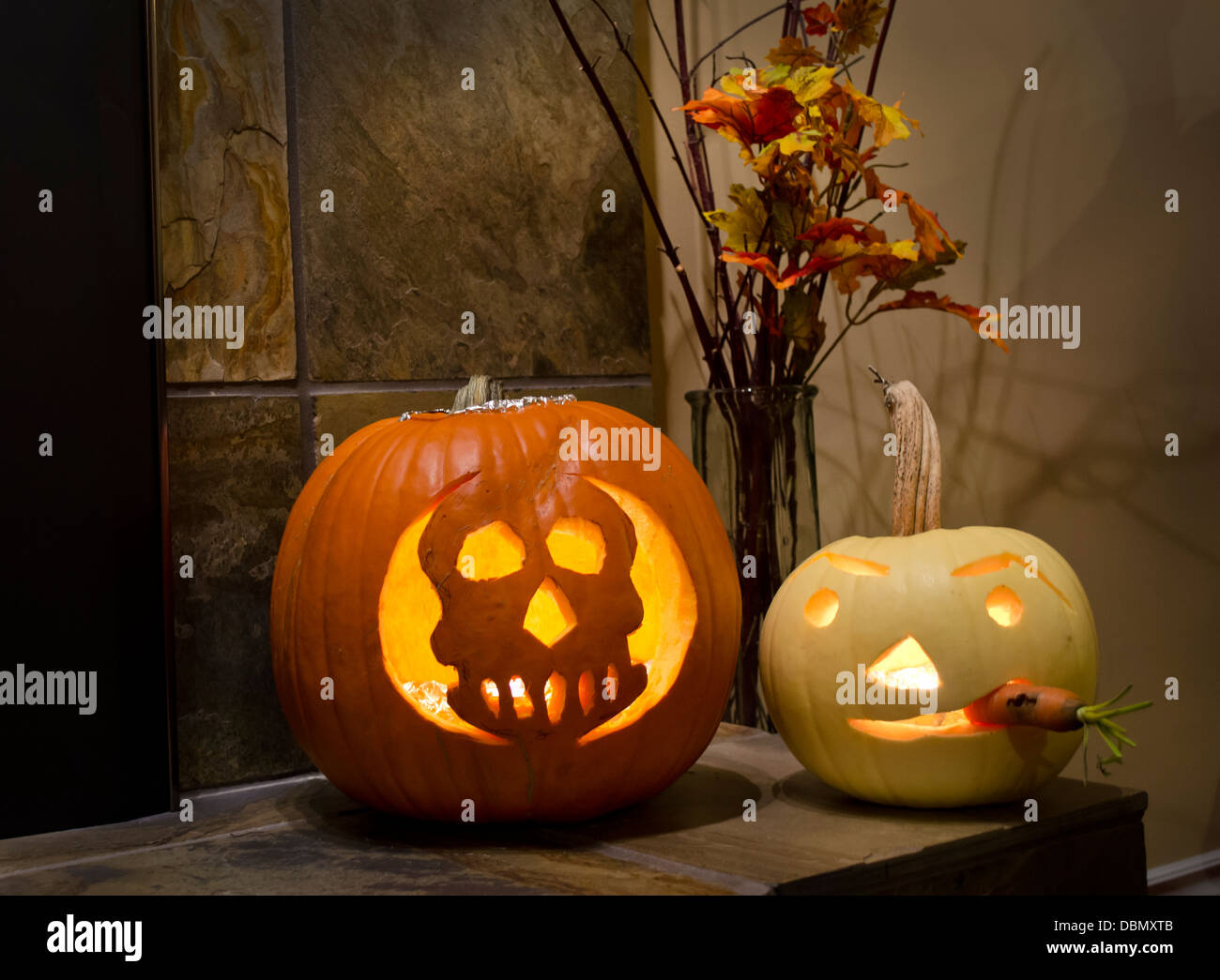 Zwei geschnitzte Halloween Kürbisse, Jack o Laternen, zu Hause. Weiß Kürbis und orange Schädel Kürbis. Stockfoto