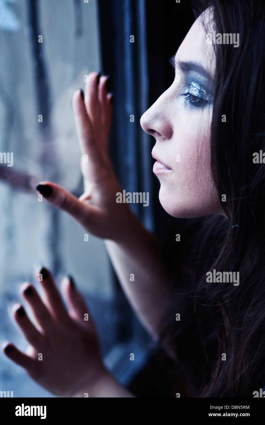 Junge Frau mit langen Haaren Blick durch Fenster, Zagreb, Kroatien, Europa Stockfoto