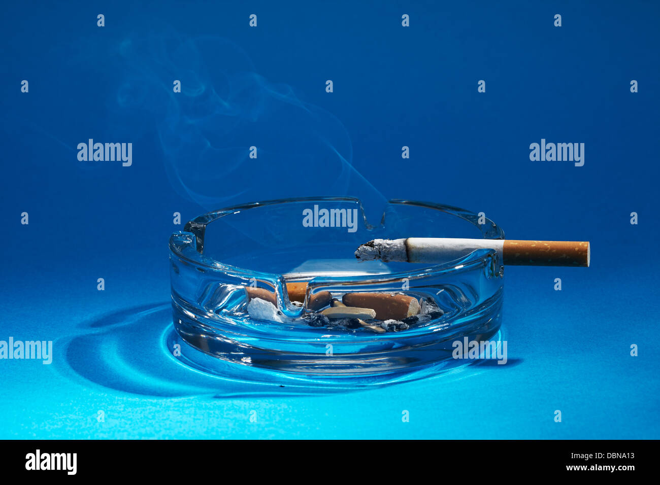 Aschenbecher mit brennenden Zigaretten Stockfoto