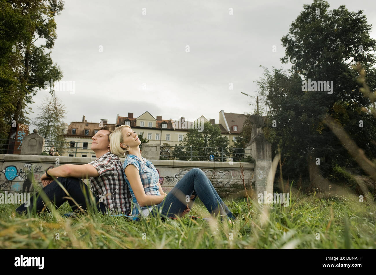 Junges Paar entspannt in einem Park, Munich, Bavaria, Germany Stockfoto