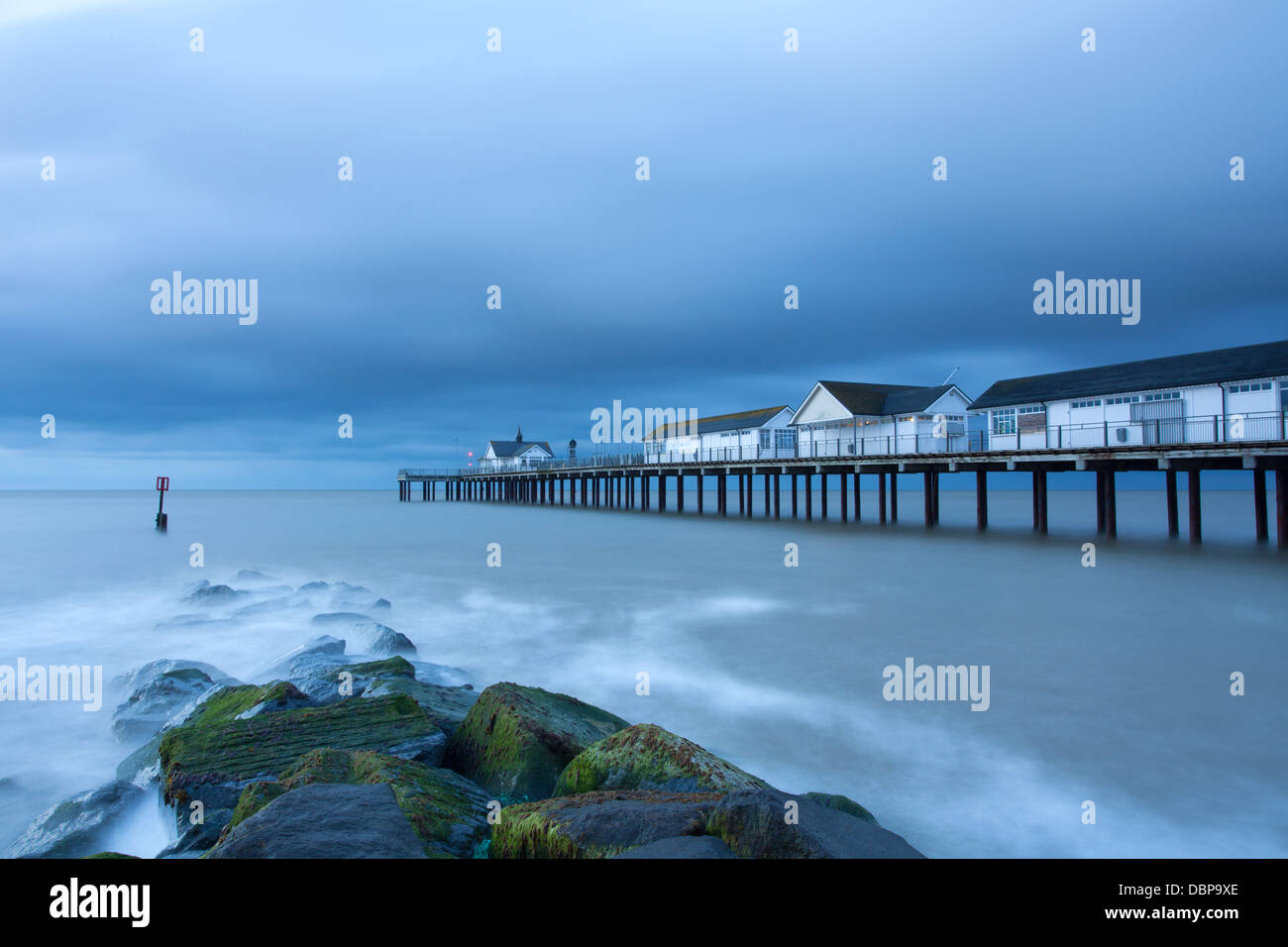 Southwold Pier, Strand und Meer Abwehrkräfte an einem Sommermorgen bei Sonnenaufgang. Stockfoto
