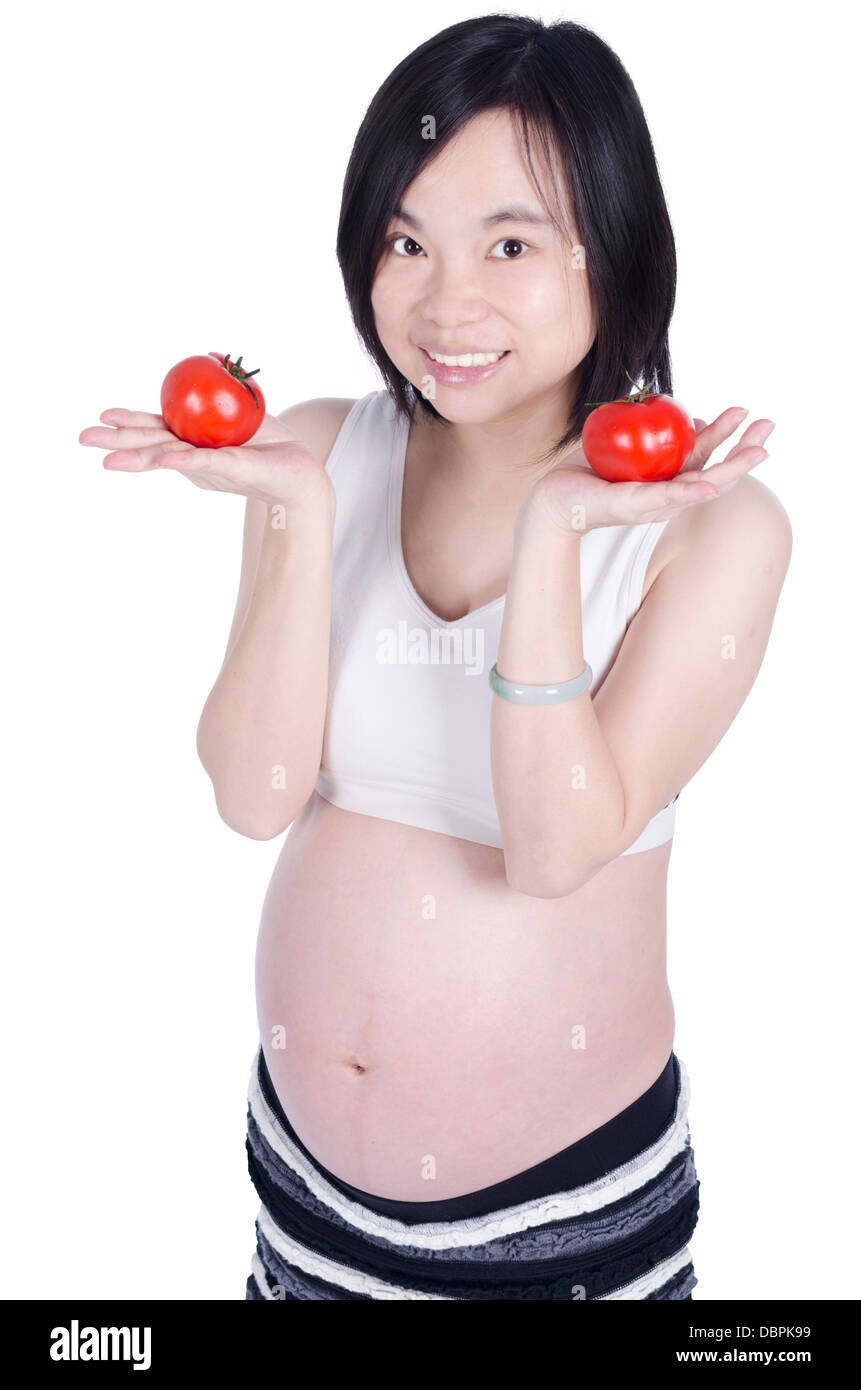 Schöne schwangere Frau mit frischen Tomaten mit der hand isoliert auf weißem Hintergrund Stockfoto