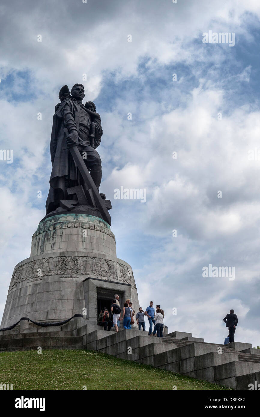 Sowjetisches Kriegsdenkmal, Treptower Park, Berlin. Statue des sowjetischen Soldaten, der Kind und Schwert hält und auf gebrochenem Hakenkreuz trampelt.. Russisches Denkmal Stockfoto