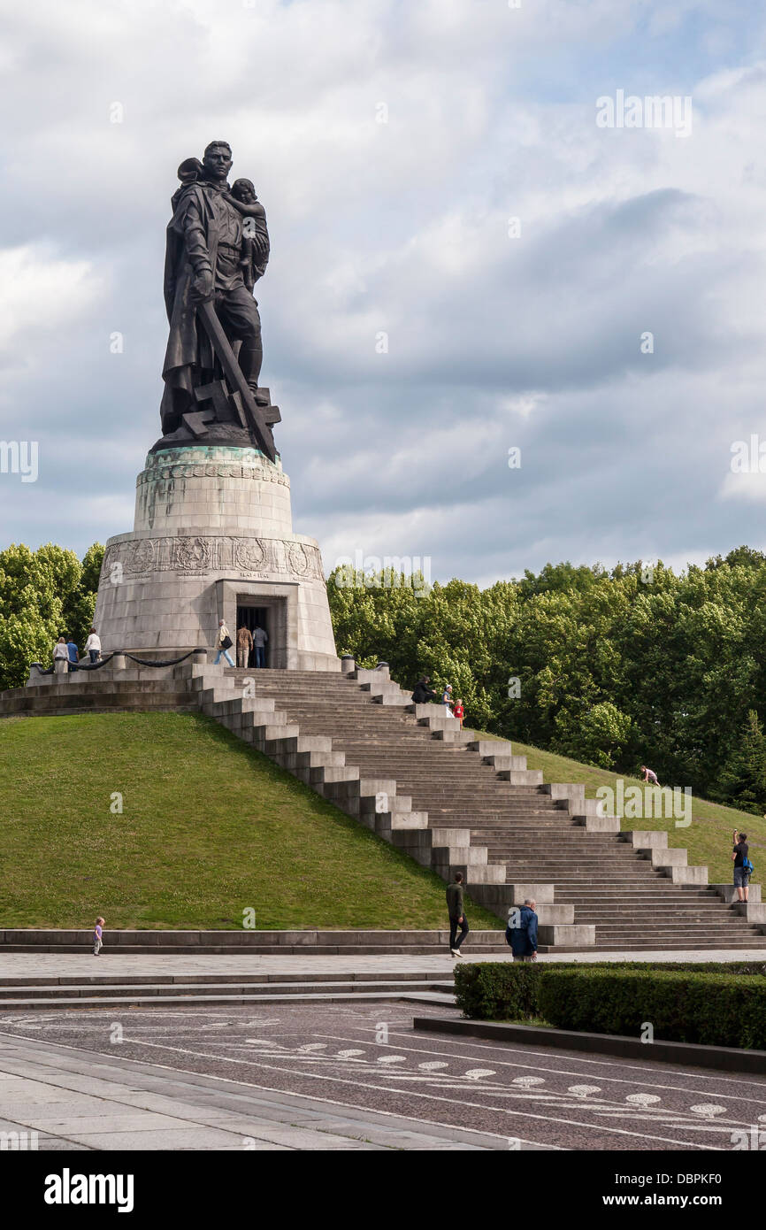 Sowjetisches Kriegsdenkmal, Treptower Park, Berlin. Statue des sowjetischen Soldaten, der Kind und Schwert hält und auf gebrochenem Hakenkreuz trampelt.. Russisches Denkmal Stockfoto
