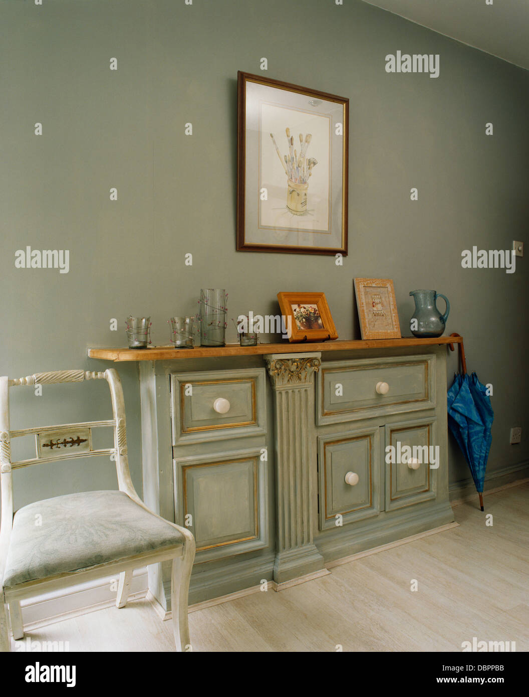 Blasse graue Konsole mit distressed Effekt Lackierung in grau mit weiß lackierten Stuhl Stockfoto