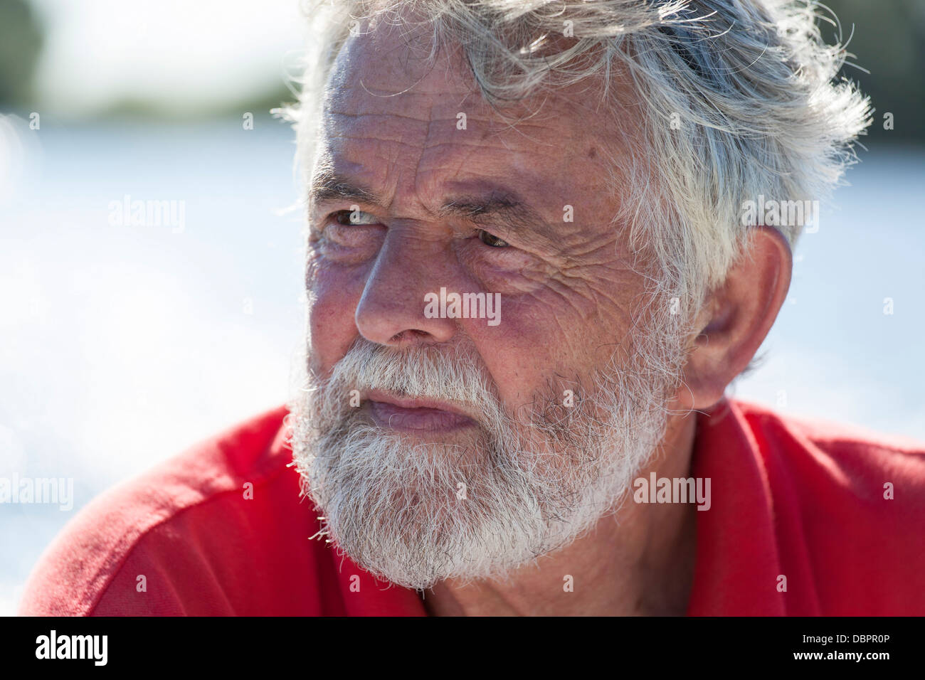 Porträt senior Mann 60-70 mit einem Bart mit Wasser im Hintergrund Stockfoto
