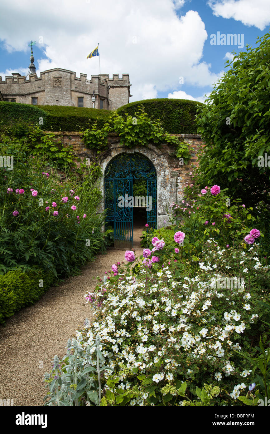 Einen Einblick in Rousham House aus in die bunte ummauerten Garten mit seinen verzierten Tor und floralen Grenzen, Oxfordshire, England Stockfoto