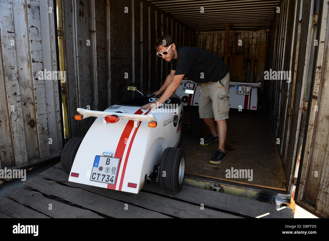 Mitarbeiter Ronald Ramson schiebt ein Mini Hot-Rod aus einem Container in der Werkstatt auf dem RAW Gelände in Berlin, Deutschland, 2. August 2013. City-Touren haben in diesen Gokarts seit Mai angeboten. Foto: MATTHIAS BALK Stockfoto