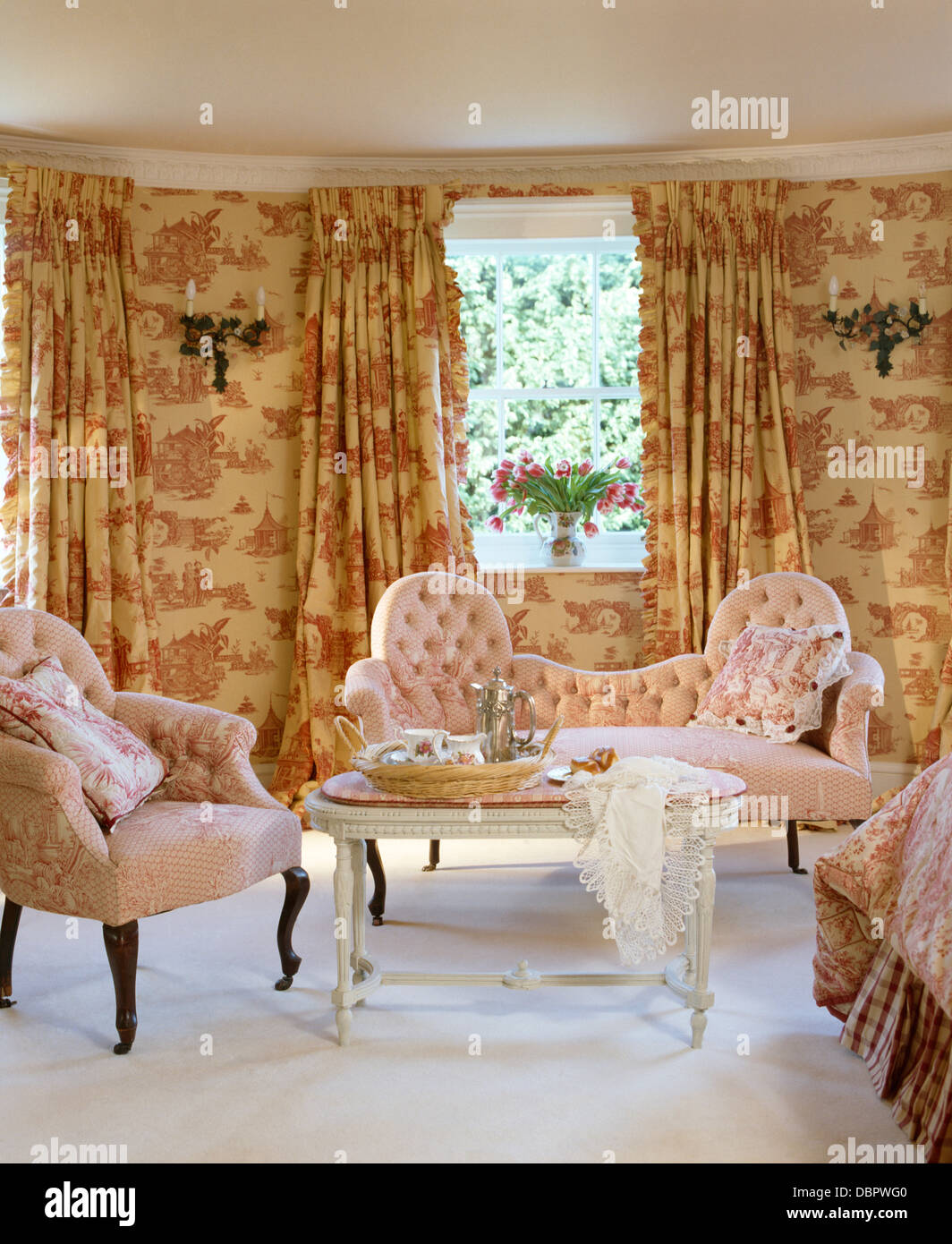 Rosa Toile-de-Jouy Gardinen und passenden Tapeten im Schlafzimmer Stadthaus  mit rosa Knopf-Rücken-Sofa und Sessel Stockfotografie - Alamy