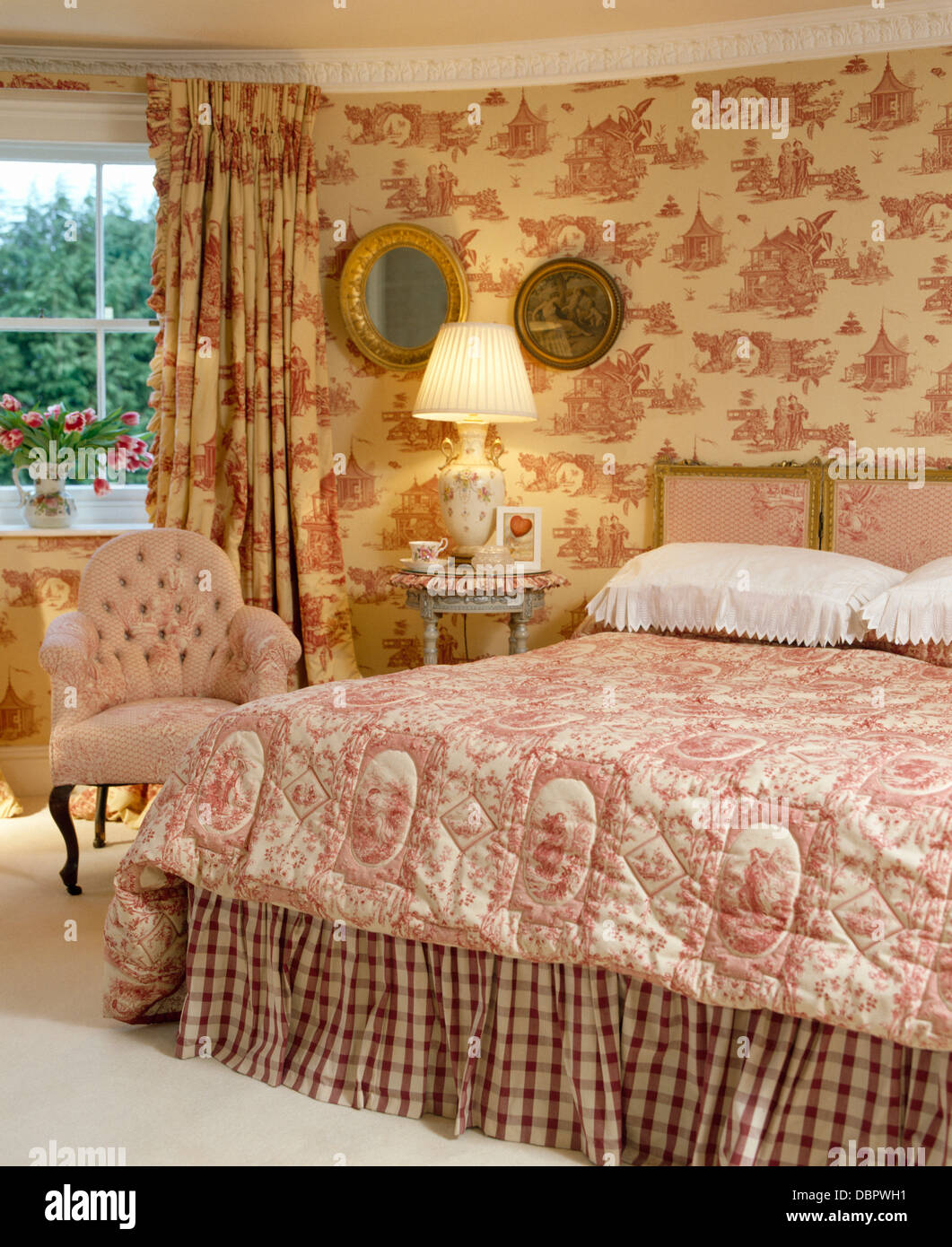 Rosa Toile-de-Jouy Gardinen und passenden Tapeten im Schlafzimmer Stadthaus  mit rosa Quilt auf Bett Stockfotografie - Alamy