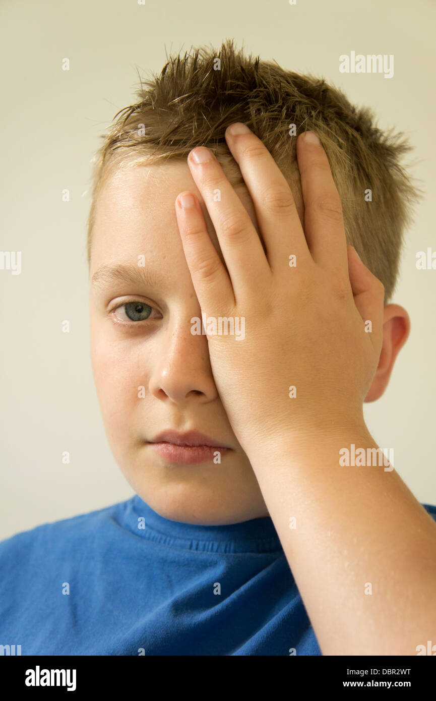 Junge hält seine Hand an den Kopf mit Kopfschmerzen Stockfoto