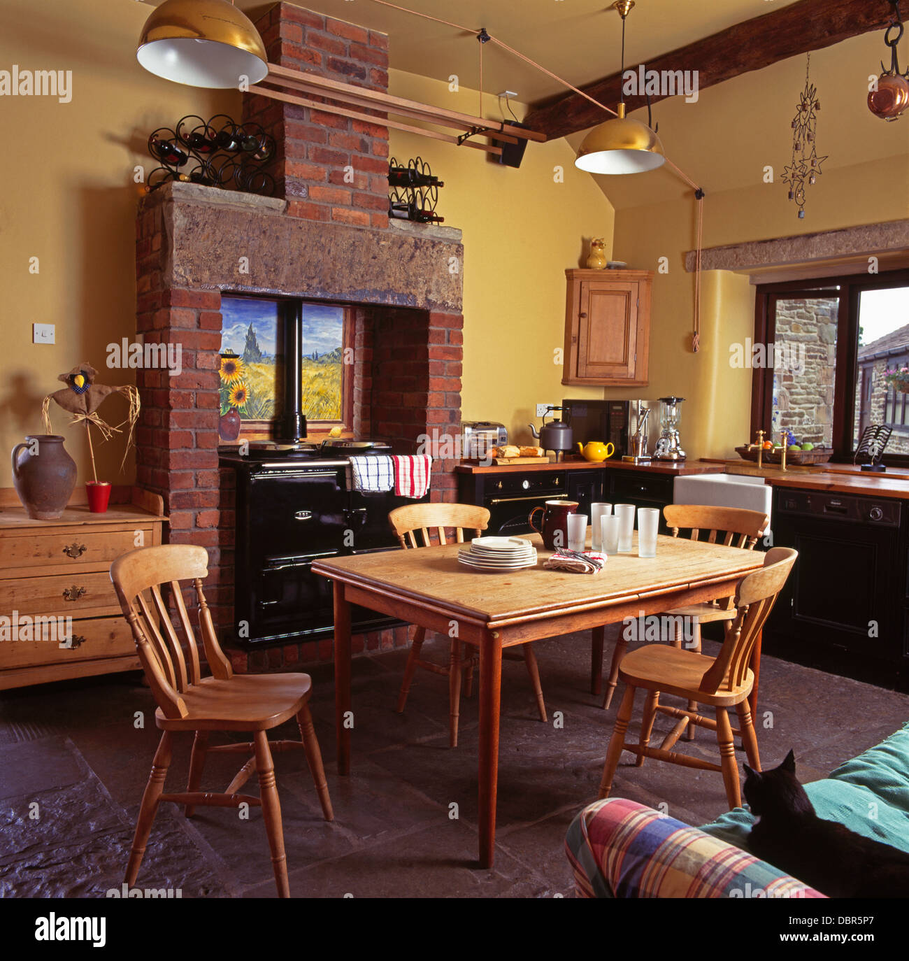Einfache Kiefer Tisch und Stühle im Bauernküche mit Wäscheständer über  schwarze Aga Stockfotografie - Alamy