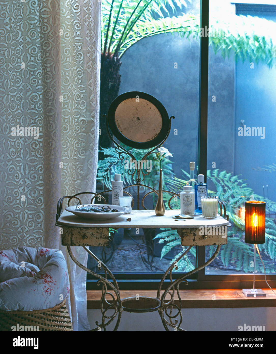 Altfranzösisch Metall Schminktisch mit fester Spiegel vor Glastüren mit  gemusterten Vorhang im Loft Conversion-Schlafzimmer Stockfotografie - Alamy