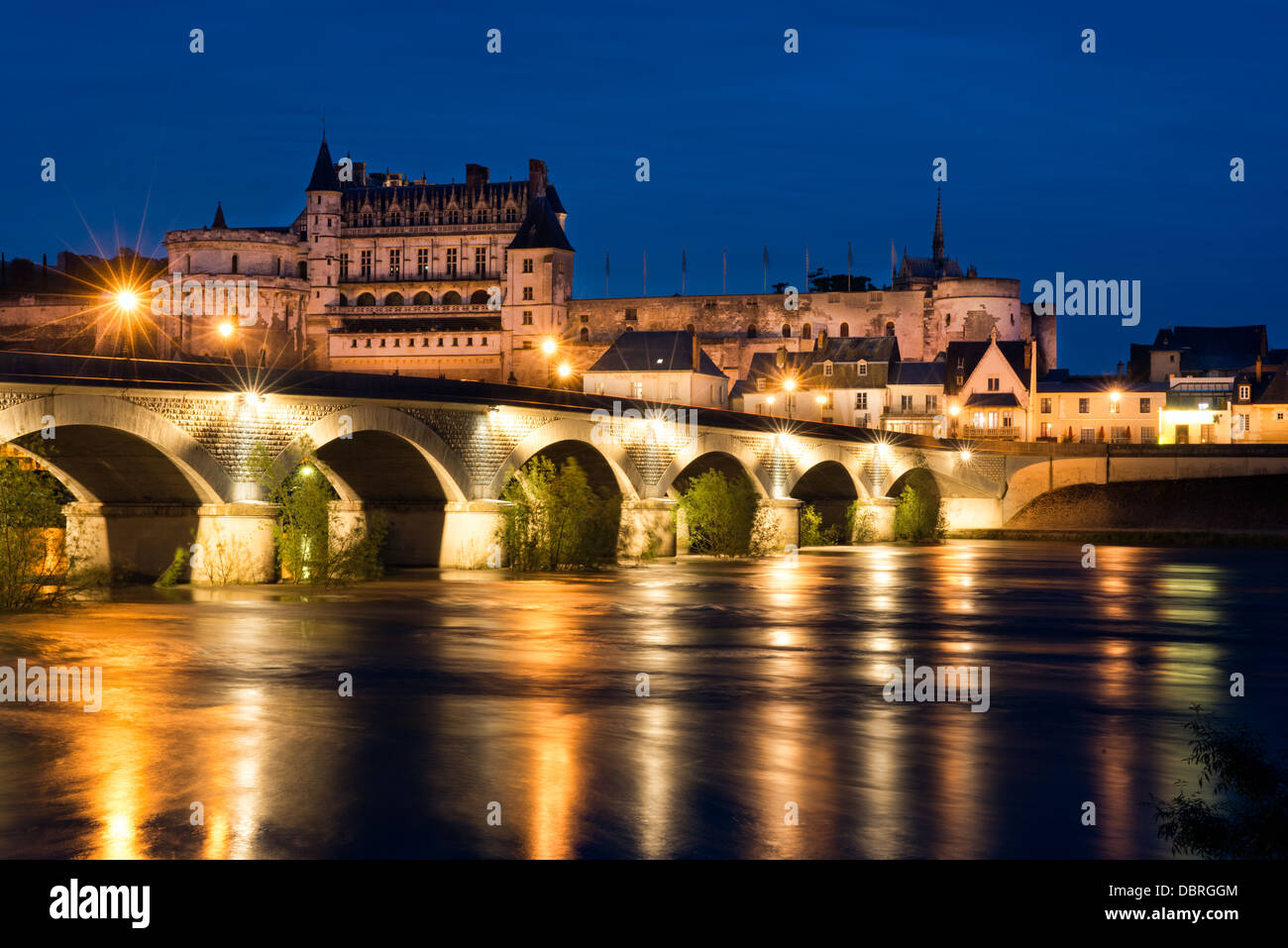 Das historische Schloss, Stadt & Brücke in Amboise abends beleuchtet und spiegelt sich in den Fluss Loire, Frankreich Stockfoto