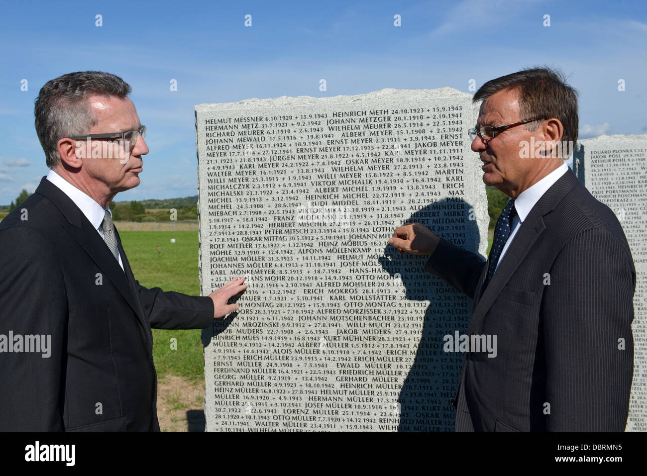 Reinhard Führer (L), Präsident des Deutsche Kriegsgräberfürsorge und Defence Minister Thomas de Maiziere (L) steht auf einer Granitplatte mit den Namen der Toten deutschen Soldaten, die während der Einweihung der deutschen Soldatenfriedhof in Dukhovshchina, Oblast Smolensk, Russland, 3. August 2013 eingraviert. Der Friedhof ist die letzte Ruhestätte für 70.000 deutschen Soldaten, die während des zweiten Weltkriegs in Russland gestorben. Foto: UWE ZUCCHI Stockfoto