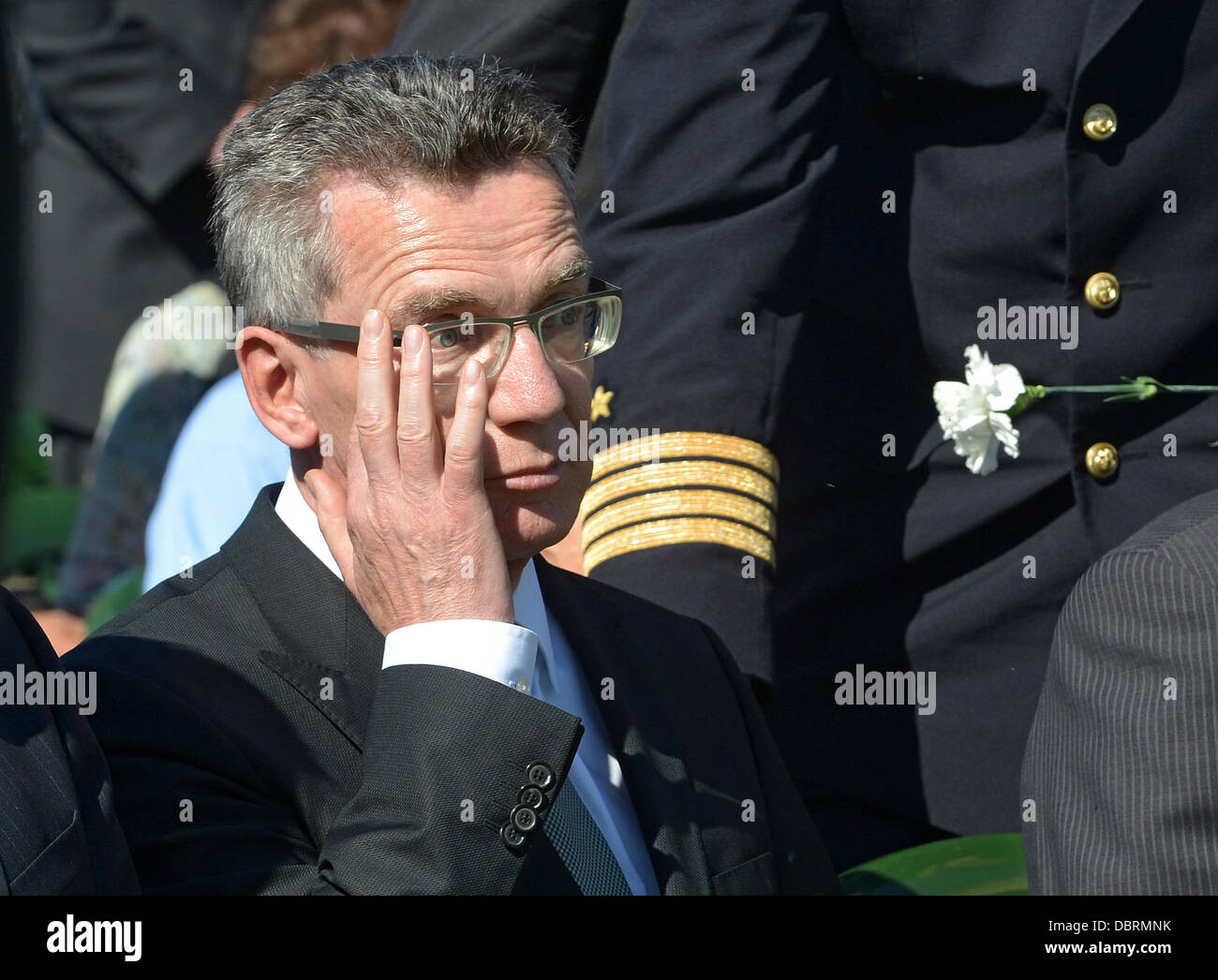 German Defence Minister Thomas de Maiziere wischt sein Auge während der Einweihung der deutschen Soldatenfriedhof in Dukhovshchina, Oblast Smolensk, Russland, 3. August 2013. Der Friedhof ist die letzte Ruhestätte für 70.000 deutschen Soldaten, die während des zweiten Weltkriegs in Russland gestorben. Foto: UWE ZUCCHI Stockfoto