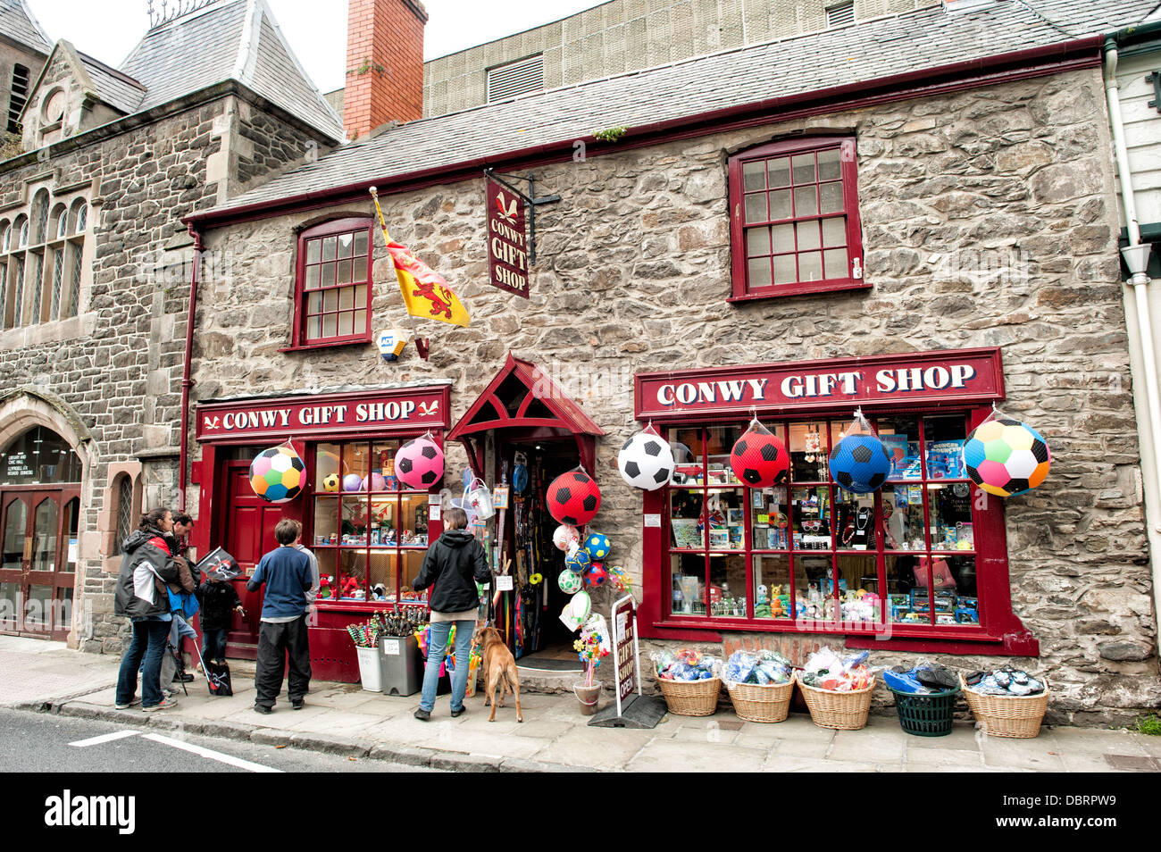 Geschäfte auf Castle Street, einer der Hauptstraßen von Conwy, die parallel zum Meer verläuft. Conwy ist eine historische Festungsstadt am bekanntesten für Conwy Castle, das am südlichen Ende der Castle Street steht. Stockfoto