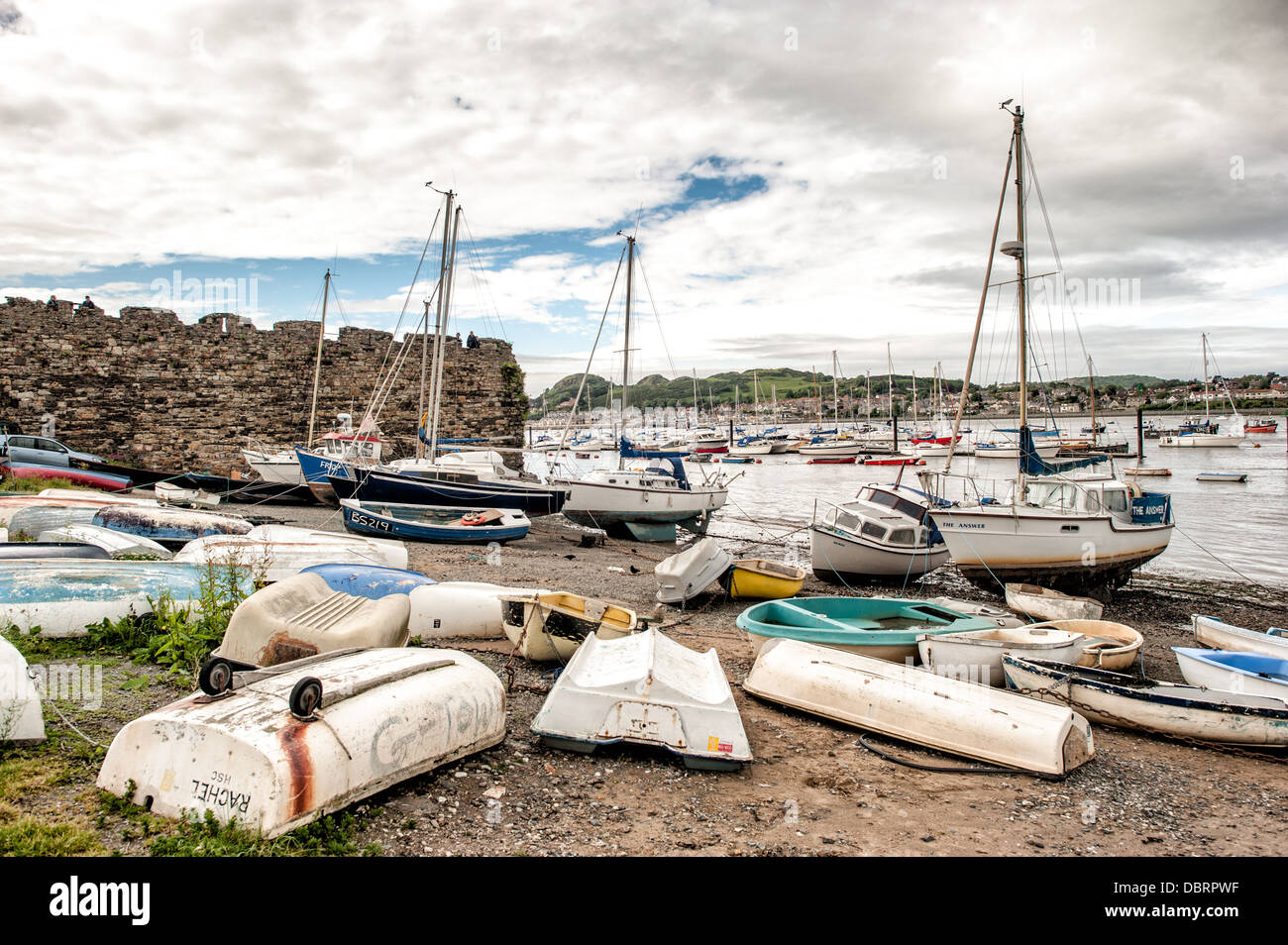 Boote auf dem kiesigen Strand vor der Stadt Conwy auf dem Fluss Conwy in Nord-Wales. Stockfoto