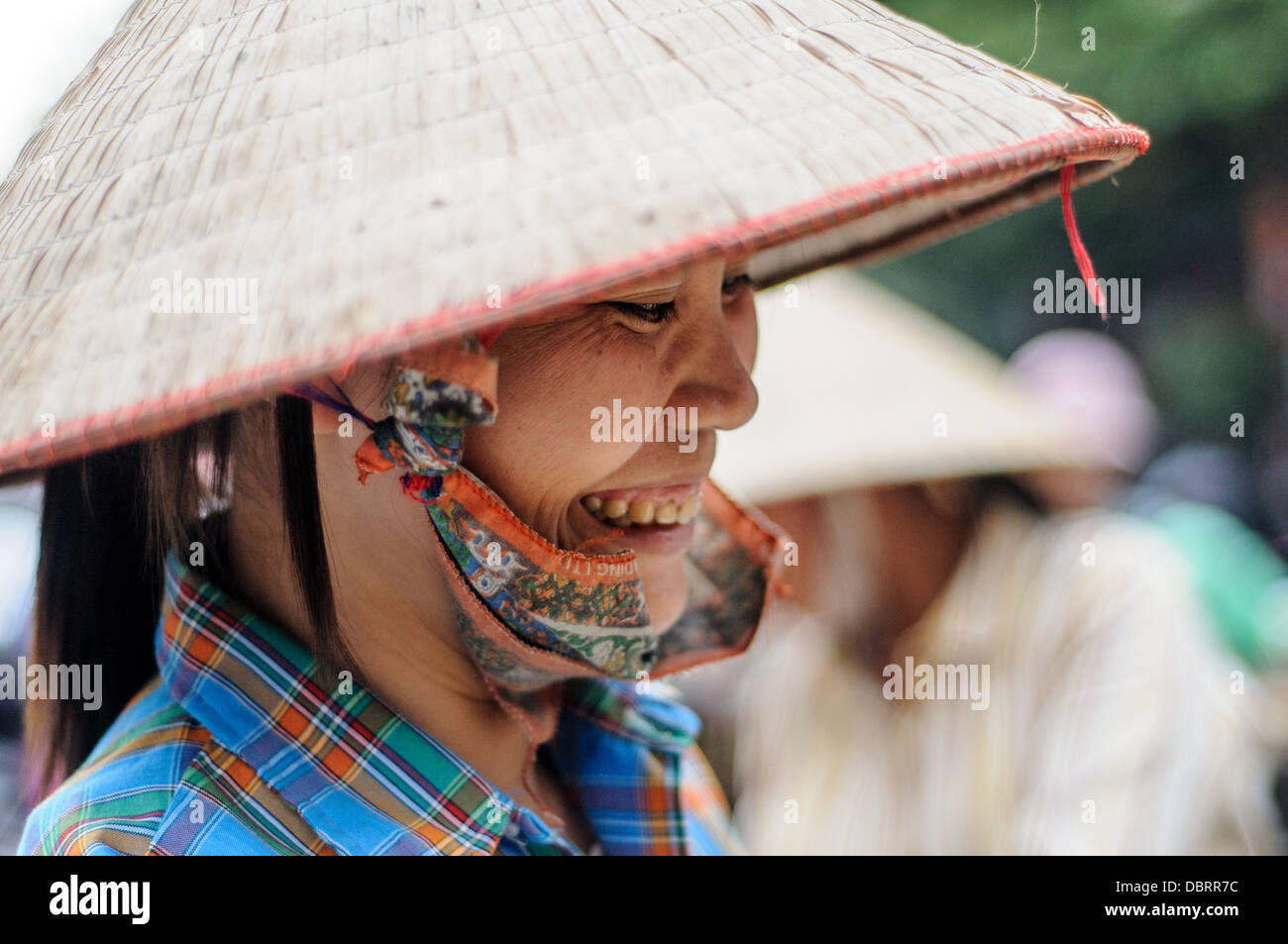 Vietnamese Conical hat Woman Food Market Hanoi Vietnam // HANOI, Vietnam — Eine Frau, die einen traditionellen vietnamesischen konischen Hut auf einem Lebensmittelmarkt in Hanoi, Vietnam, trägt. Stockfoto