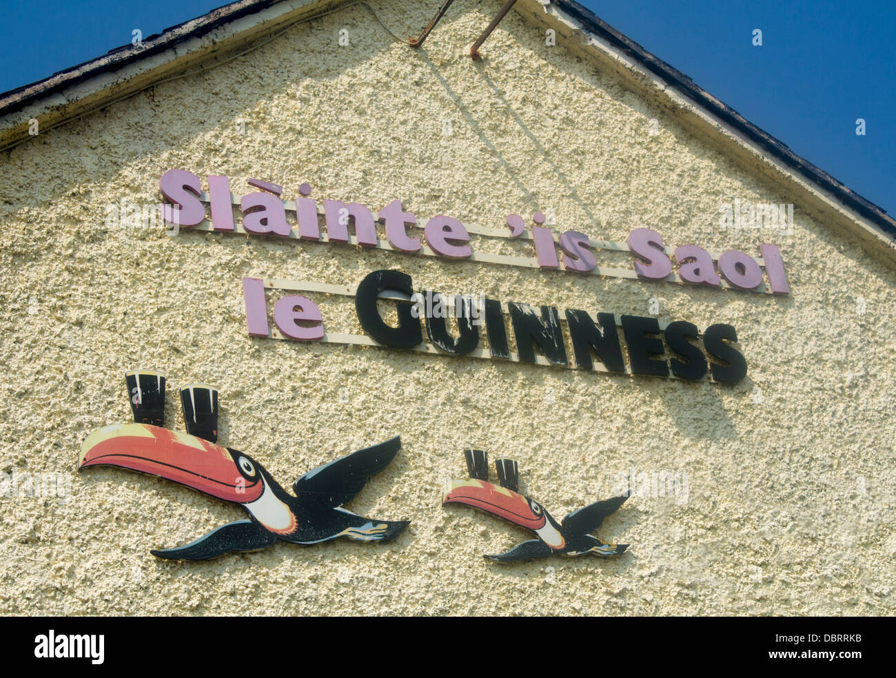 Guinness-fliegende Tukane Wandkunst und Zeichen auf Gälisch auf Pub Außenseite Spiddal County Galway Irland Stockfoto