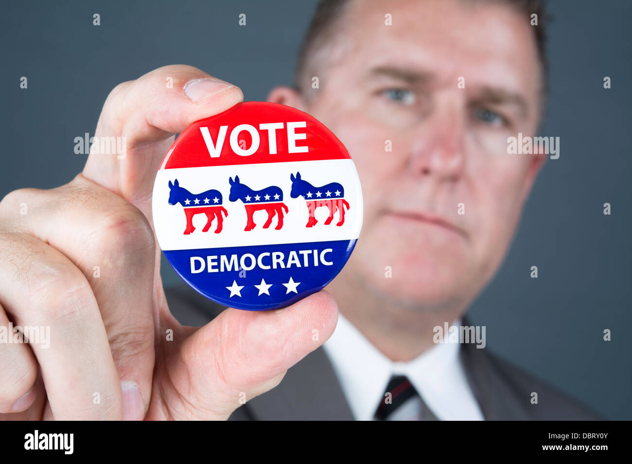 Ein Politiker hält eine demokratische Abstimmung Abzeichen Förderung seiner Pundants zu stimmen. Stockfoto