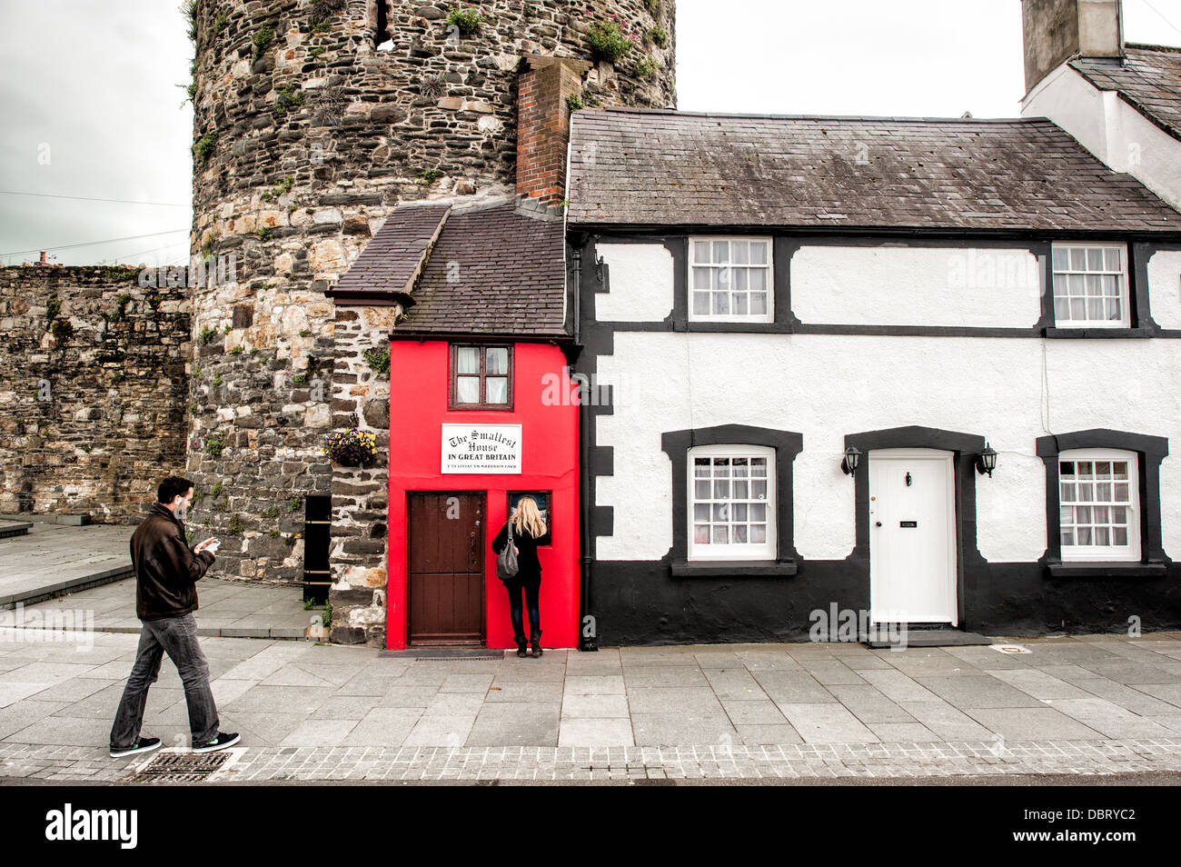 CONWY, Wales – Quay House, auch bekannt als das kleinste Haus Großbritanniens, steht neben den Mauern von Conwy Castle. Bis 1900 war es eine funktionale, aber winzige Residenz und heute ist es eine beliebte Touristenattraktion, die Besucher in diese historische walisische Stadt zieht. Stockfoto