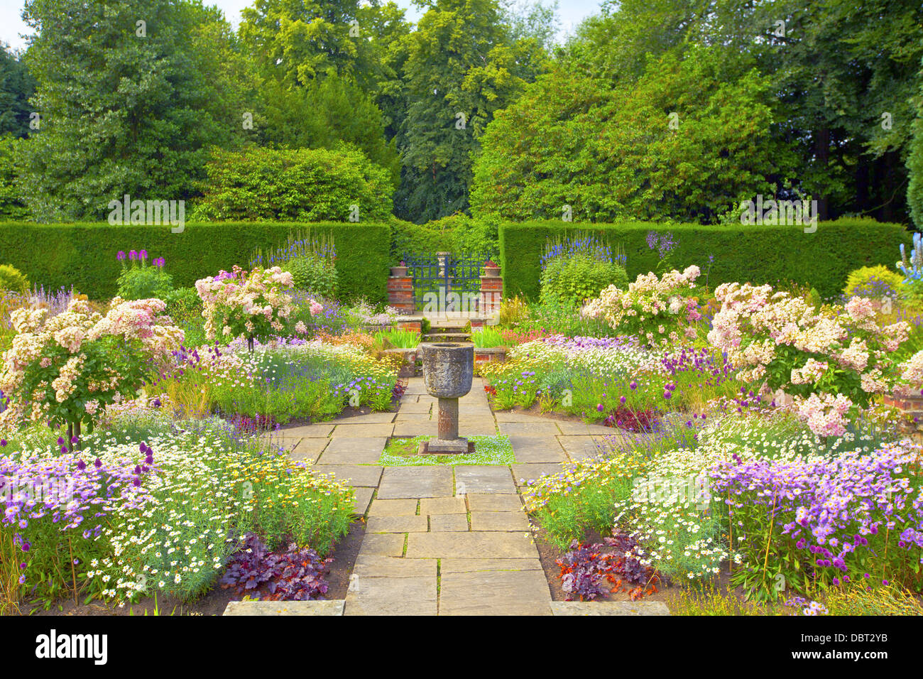 Gekennzeichneten englischen Sommergarten mit steinernen Vase Ornament. Stockfoto