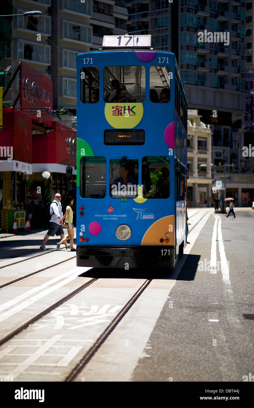 Die Straßenbahn, die durch Wan Chai an einem sonnigen Nachmittag. Die Straßenbahn mit der hk Tourism Board eingerichtet ist Stockfoto