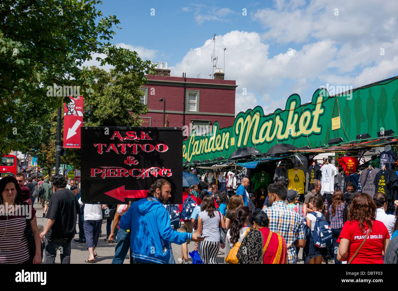 Der Mensch in der Nähe von Camden Markt hält ein Schild, das auf einen Platz für Tattoos und Piercings. London, England, UK. Stockfoto