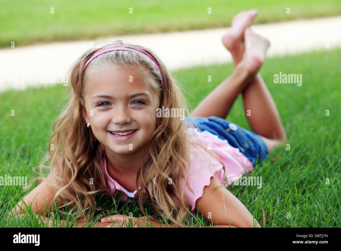 hübsche blonde Mädchen Verlegung außerhalb in Rasen Stockfoto