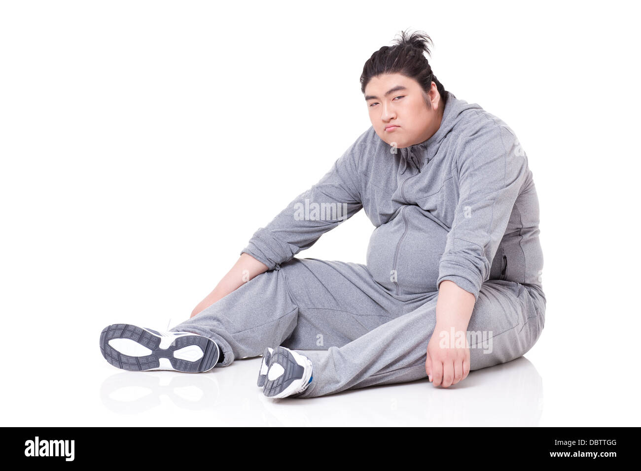 Unglücklich dicker Mann auf dem Boden sitzend Stockfoto