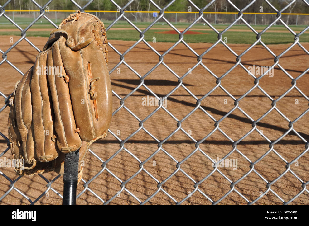 Baseballschläger und Handschuh mit Baseball-Feld hinter Stockfoto