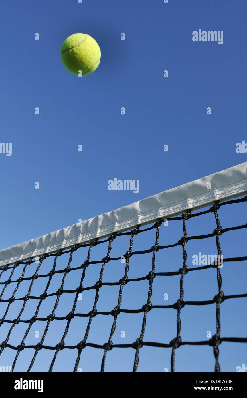 Tennis fliegenden Ball über das Netz beim Tennis spielen gegen den klaren blauen Himmel Stockfoto