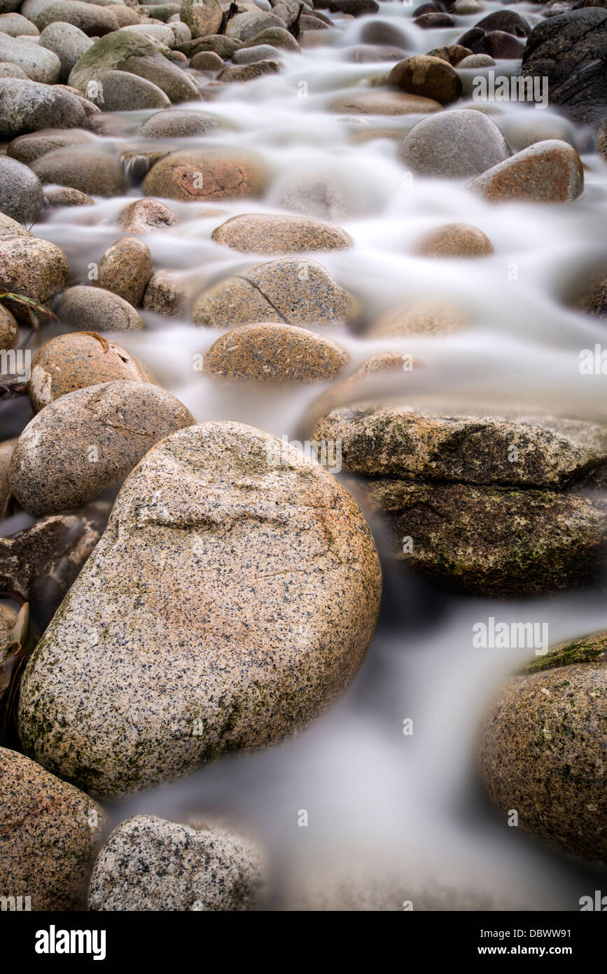 Strom fließt über Wasser getragen Runde Felsen Stockfoto