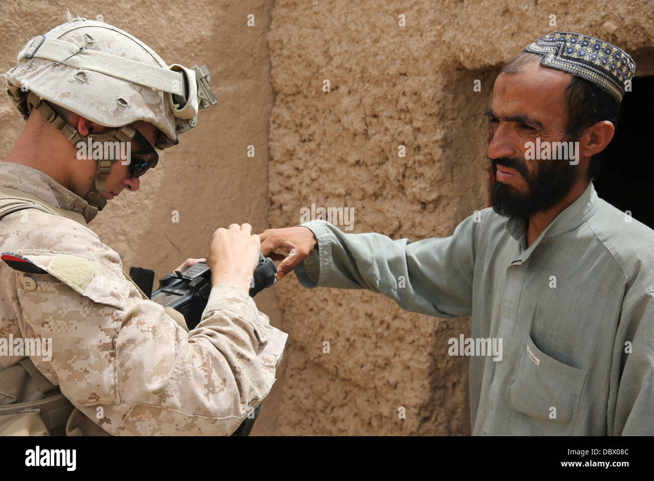 US Marine Corps Lance Cpl. Großbritannien Morris mit Fox Company sammelt Informationen von einem afghanischen Mann mit einer sicheren elektronischen Einschreibung Baukastensystem während einer Patrouille 29. Juli 2013 in Washir, Provinz Helmand, Afghanistan. Stockfoto