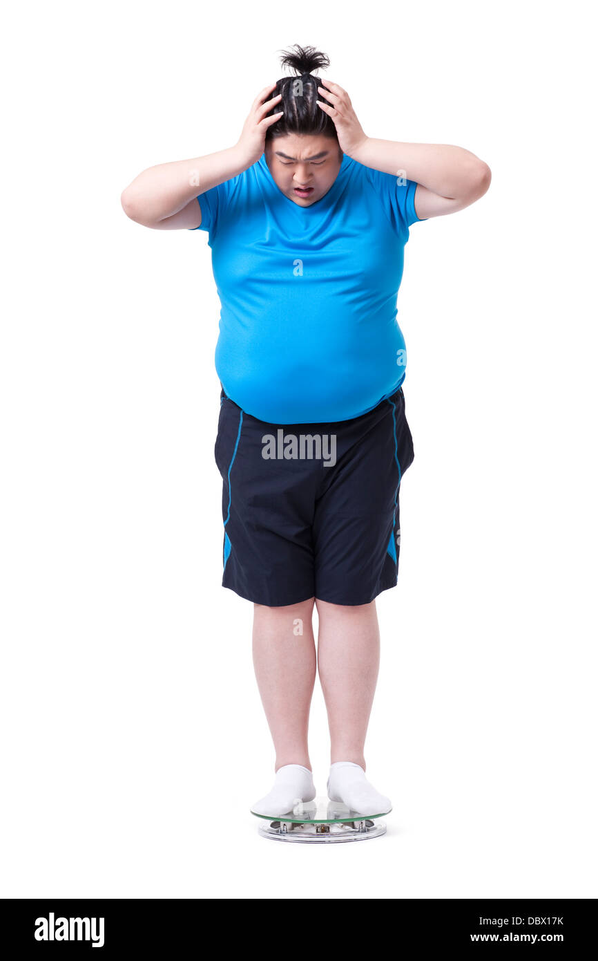 Übergewichtiger Mann im Maßstab, schockiert Stockfoto