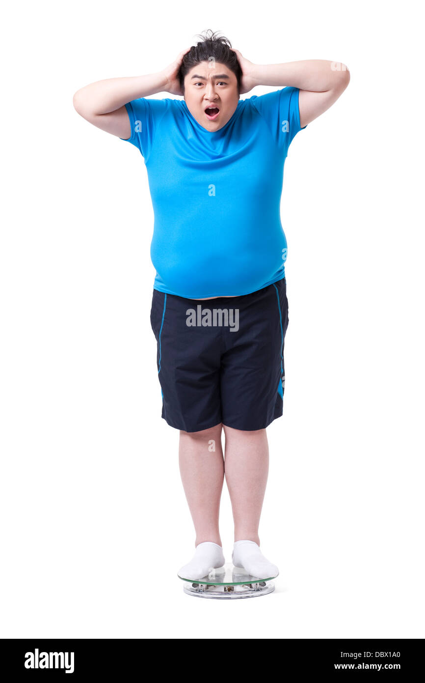 Übergewichtiger Mann im Maßstab, schockiert Stockfoto