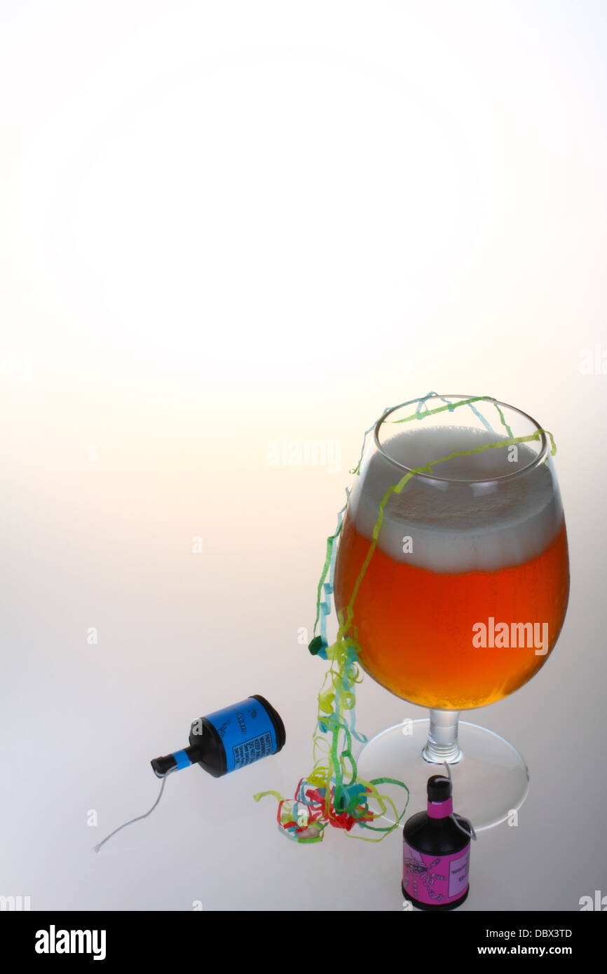 Glas Bier mit Party Poppers und Streamer mit Platz für Kopie Stockfoto