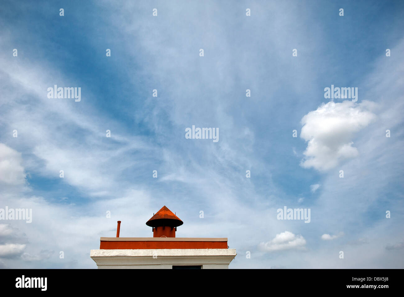 Schornstein und blauer Himmel mit wirbelnden Wolken Stockfoto